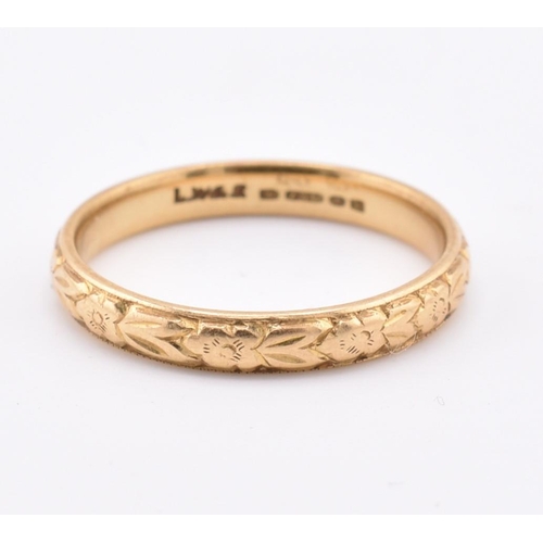 172 - A hallmarked 18ct gold band ring. The ring having foliate decoration to the band. Hallmarked for Lon... 