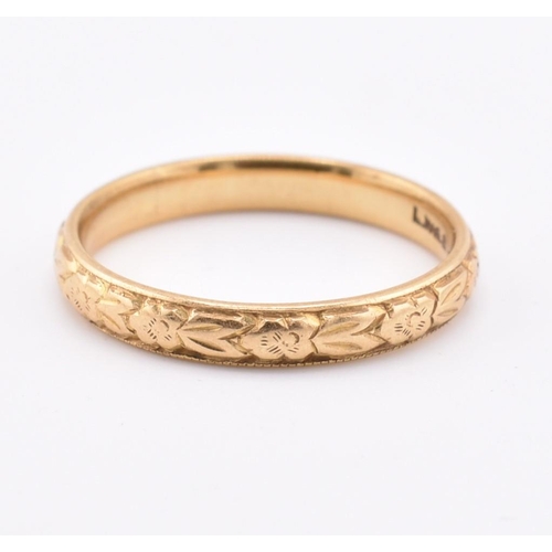 172 - A hallmarked 18ct gold band ring. The ring having foliate decoration to the band. Hallmarked for Lon... 