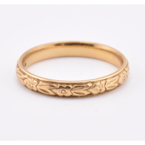 172 - A hallmarked 18ct gold band ring. The ring having foliate decoration to the band. Hallmarked for Lon... 