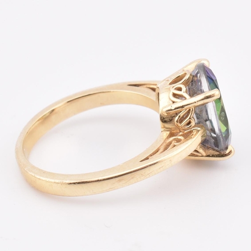 178 - A 14ct gold and mystic topaz ring. The 14ct yellow gold ring set with a four claw set oval cut mysti... 