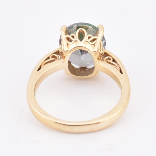 178 - A 14ct gold and mystic topaz ring. The 14ct yellow gold ring set with a four claw set oval cut mysti... 