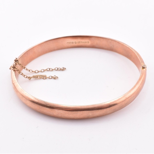 208 - A hallmarked 9ct gold hinged bangle. The early 20th century 9ct rose gold bangle hinged bangle havin... 