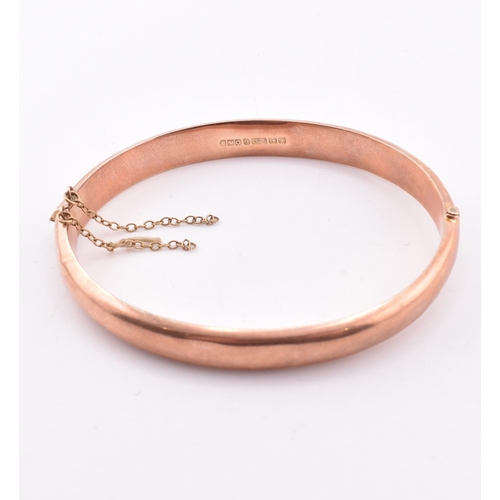 208 - A hallmarked 9ct gold hinged bangle. The early 20th century 9ct rose gold bangle hinged bangle havin... 