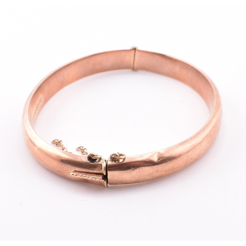 208 - A hallmarked 9ct gold hinged bangle. The early 20th century 9ct rose gold bangle hinged bangle havin... 