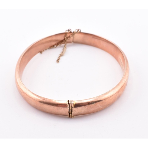 208 - A hallmarked 9ct gold hinged bangle. The early 20th century 9ct rose gold bangle hinged bangle havin... 