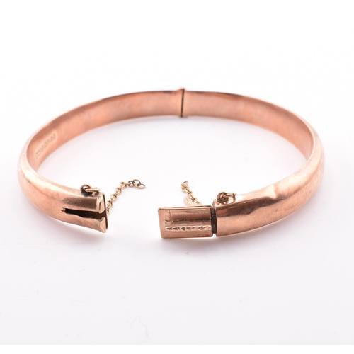 208 - A hallmarked 9ct gold hinged bangle. The early 20th century 9ct rose gold bangle hinged bangle havin... 