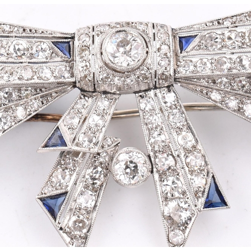 21 - An Art Deco ribbon bow sapphire and diamond brooch pin. The brooch set 104 old and eight cut diamond... 