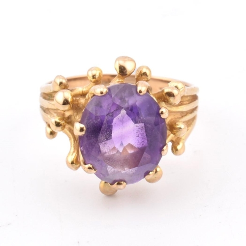 243 - A hallmarked 9ct gold and amethyst cocktail ring. The 9ct yellow gold ring having a single eight cla... 