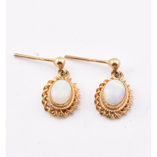 265 - A pair of hallmarked 9ct gold and opal pendant earrings AF. The 9ct yellow gold earrings having a mi... 