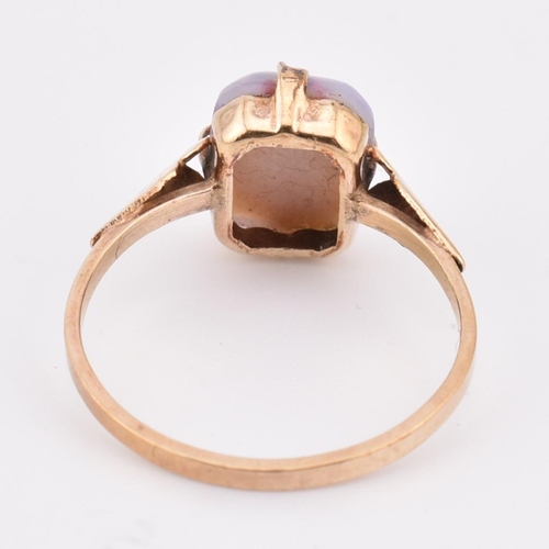 275 - A 9ct gold and slocum stone ring. The 9ct yellow gold ring set with a slocum stone cabochon to taper... 