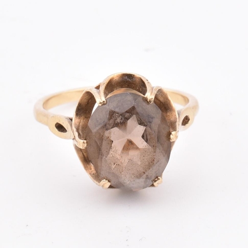 278 - A hallmarked 9ct gold and smoky quartz ring. The 9ct yellow gold ring set with a three-claw set oval... 