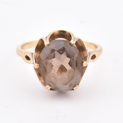 278 - A hallmarked 9ct gold and smoky quartz ring. The 9ct yellow gold ring set with a three-claw set oval... 