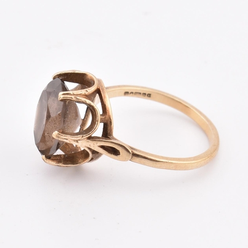 278 - A hallmarked 9ct gold and smoky quartz ring. The 9ct yellow gold ring set with a three-claw set oval... 