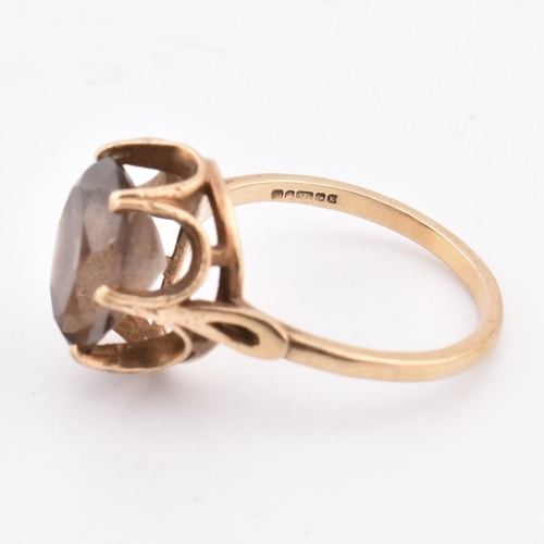 278 - A hallmarked 9ct gold and smoky quartz ring. The 9ct yellow gold ring set with a three-claw set oval... 