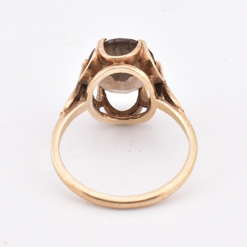 278 - A hallmarked 9ct gold and smoky quartz ring. The 9ct yellow gold ring set with a three-claw set oval... 