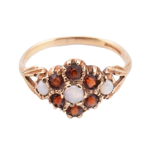 287 - A hallmarked 9ct gold opal and garnet cluster ring. The 9ct yellow gold ring set with a central roun... 