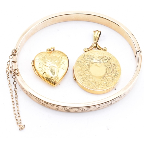 290 - A 9ct gold core bangle and two rolled gold necklace pendants. The lot to include a 9ct gold core eng... 