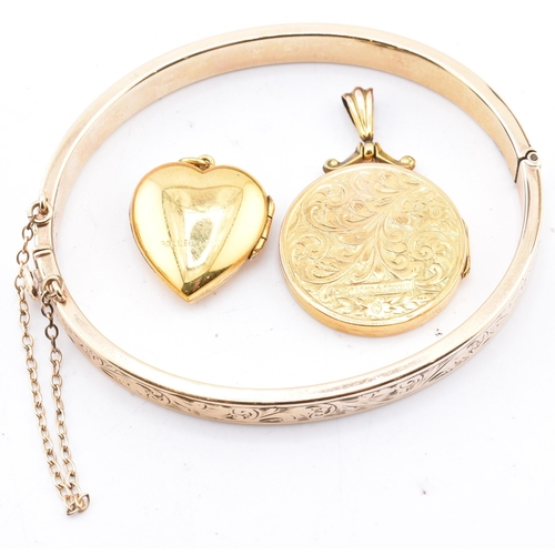 290 - A 9ct gold core bangle and two rolled gold necklace pendants. The lot to include a 9ct gold core eng... 