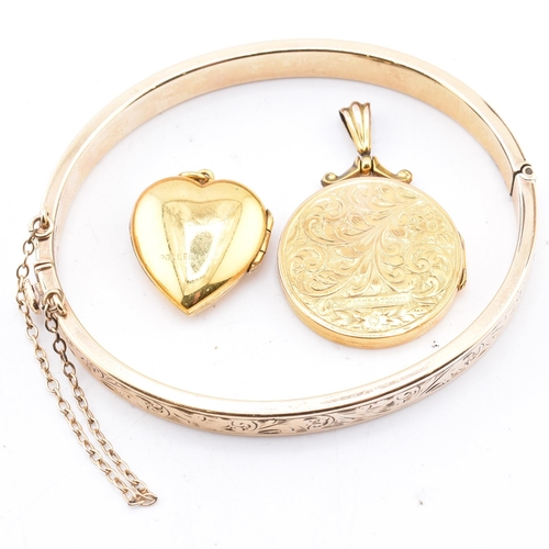 290 - A 9ct gold core bangle and two rolled gold necklace pendants. The lot to include a 9ct gold core eng... 