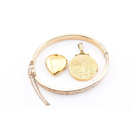 290 - A 9ct gold core bangle and two rolled gold necklace pendants. The lot to include a 9ct gold core eng... 