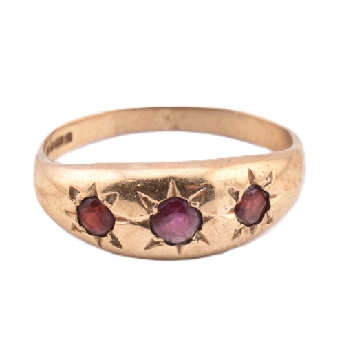 291 - A hallmarked 9ct gold and red stone gypsy ring. The 9ct yellow gold gypsy ring set with three star s... 