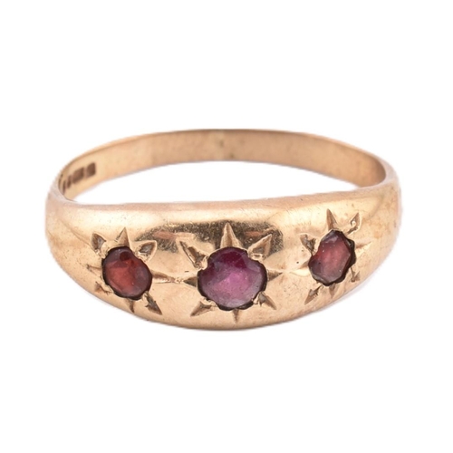 291 - A hallmarked 9ct gold and red stone gypsy ring. The 9ct yellow gold gypsy ring set with three star s... 