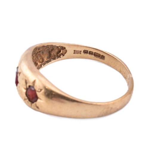 291 - A hallmarked 9ct gold and red stone gypsy ring. The 9ct yellow gold gypsy ring set with three star s... 