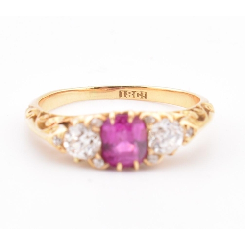 3 - An early 20th-century ruby and diamond ring. The ring set with a central cushion cut ruby flanked by... 