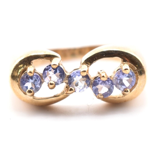 314 - A hallmarked 9ct gold and tanzanite line ring. The 9ct yellow gold ring having five round cut tanzan... 