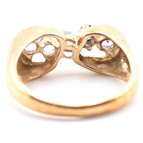 314 - A hallmarked 9ct gold and tanzanite line ring. The 9ct yellow gold ring having five round cut tanzan... 