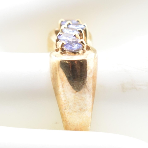 314 - A hallmarked 9ct gold and tanzanite line ring. The 9ct yellow gold ring having five round cut tanzan... 