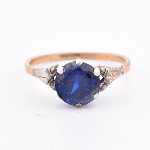 324 - An 18ct gold and blue stone ring. The 18ct gold ring set with a single six claw set round cut blue s... 