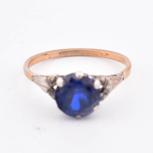 324 - An 18ct gold and blue stone ring. The 18ct gold ring set with a single six claw set round cut blue s... 