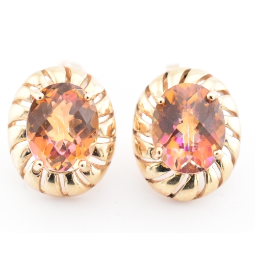 329 - A pair of hallmarked 9ct gold and mystic topaz stud earrings. The hallmarked 9ct yellow gold stud ea... 