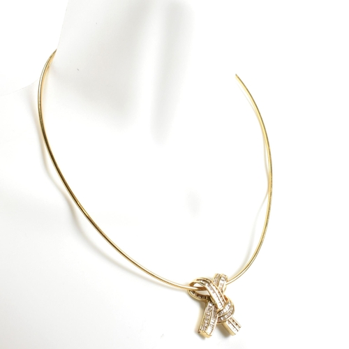 350 - A 14ct gold and diamond ribbon bow pendant necklace. The necklace is strung with a ribbon bow pendan... 