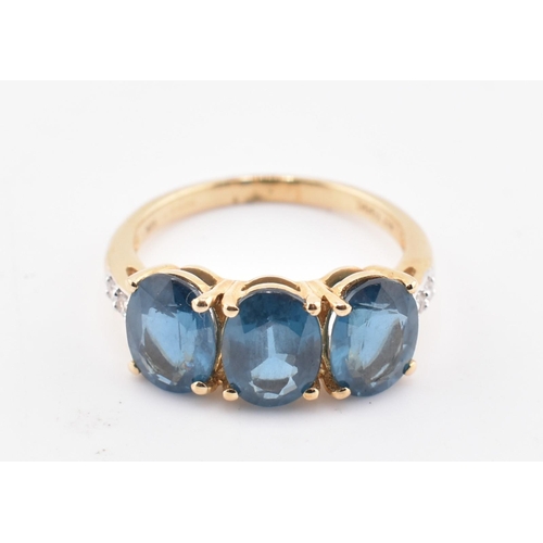 353 - A hallmarked 9ct gold, Orissa kyanite and white zircon three stone ring. The 9ct yellow gold ring se... 