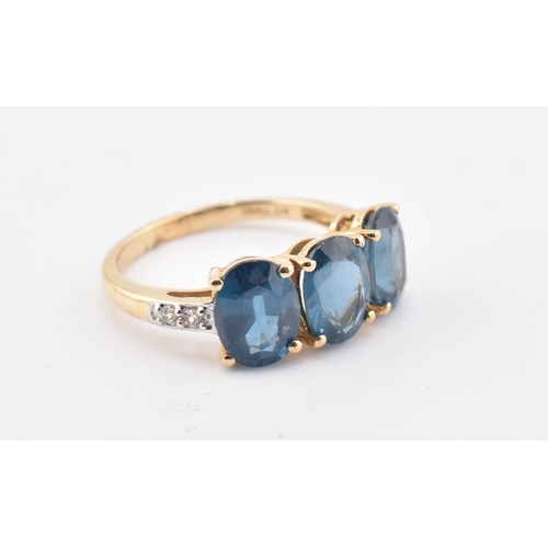 353 - A hallmarked 9ct gold, Orissa kyanite and white zircon three stone ring. The 9ct yellow gold ring se... 