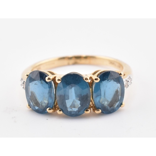 353 - A hallmarked 9ct gold, Orissa kyanite and white zircon three stone ring. The 9ct yellow gold ring se... 