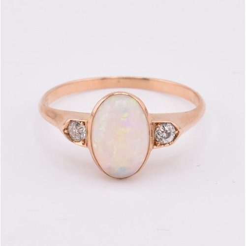 38 - An 18ct gold opal and diamond ring. The 18ct ring set with a central bezel set oval opal cabochon fl... 