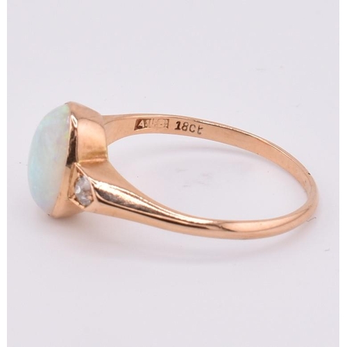 38 - An 18ct gold opal and diamond ring. The 18ct ring set with a central bezel set oval opal cabochon fl... 