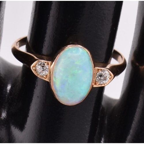 38 - An 18ct gold opal and diamond ring. The 18ct ring set with a central bezel set oval opal cabochon fl... 