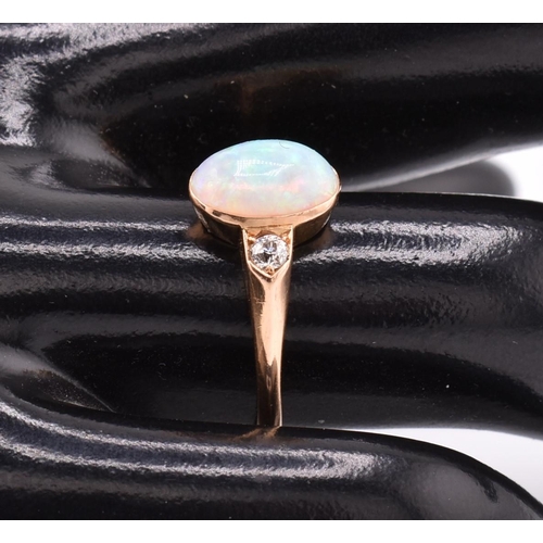 38 - An 18ct gold opal and diamond ring. The 18ct ring set with a central bezel set oval opal cabochon fl... 