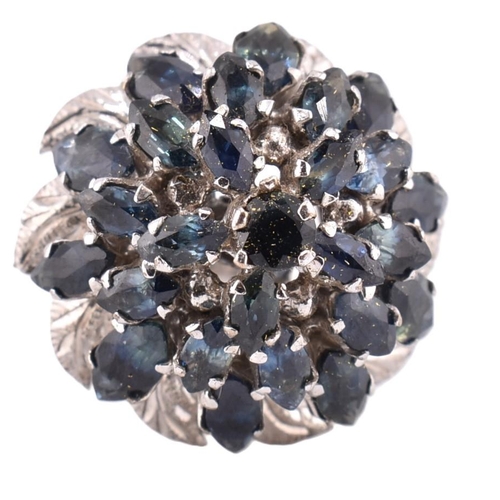 381 - An 18ct white gold and sapphire cluster ring. The large cluster 23 graduating marquise cut sapphires... 