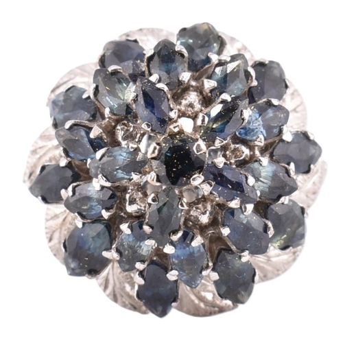 381 - An 18ct white gold and sapphire cluster ring. The large cluster 23 graduating marquise cut sapphires... 