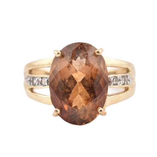 386 - A hallmarked 9ct gold imperial topaz and white topaz ring. The 9ct yellow gold ring set with a centr... 