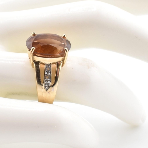 386 - A hallmarked 9ct gold imperial topaz and white topaz ring. The 9ct yellow gold ring set with a centr... 