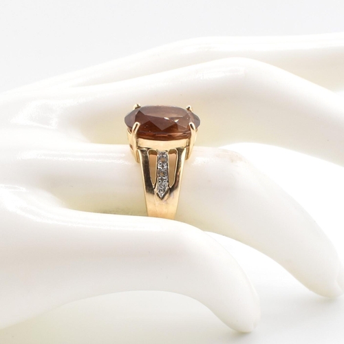 386 - A hallmarked 9ct gold imperial topaz and white topaz ring. The 9ct yellow gold ring set with a centr... 