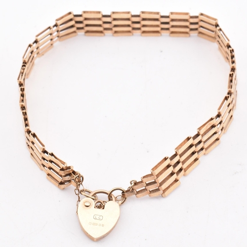 391 - A hallmarked 9ct gold gate link chain bracelet with a heart padlock. The yellow gold gate link brace... 