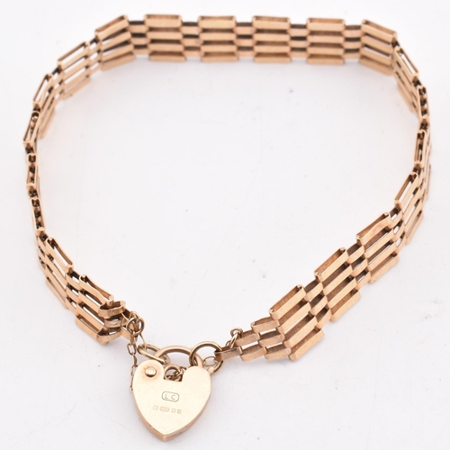 391 - A hallmarked 9ct gold gate link chain bracelet with a heart padlock. The yellow gold gate link brace... 