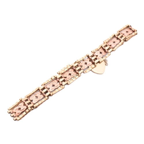 397 - A hallmarked 9ct gold gate link bracelet with heart padlock clasp. The 9ct bi-colour gold gate link ... 